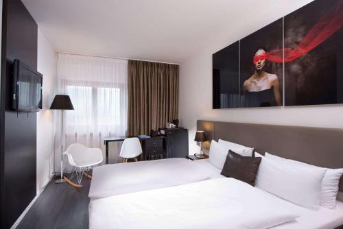 斯图加特斯图加特机场展览中心温德姆酒店的配有一张床和一张书桌的酒店客房