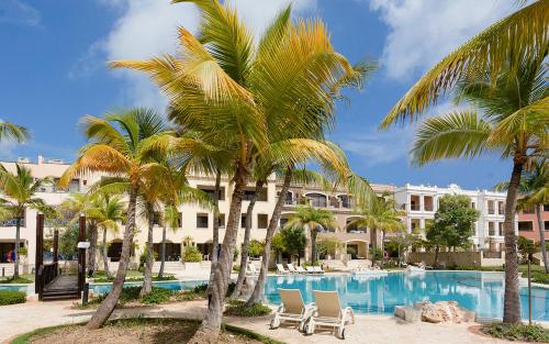 蓬塔卡纳Luxe 1 BR Cap Cana, DR - Steps Away From Pool, King Bed, Caribbean Paradise!的棕榈树和游泳池度假村
