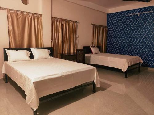 古瓦哈提Nilachal Homes的一间卧室设有两张床和蓝色的墙壁