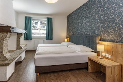 斯拉德明Appartements Landhaus Hubertus Wellness & Breakfast的酒店客房配有一张床和一个壁炉。