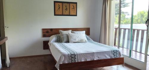 巴耶埃尔莫索El Piul的一间卧室设有一张床和一个阳台的窗户。
