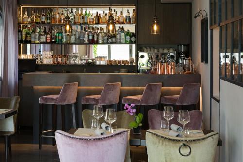 莱泽诺费拉瑞欧酒店的餐厅设有酒吧,提供椅子和酒杯