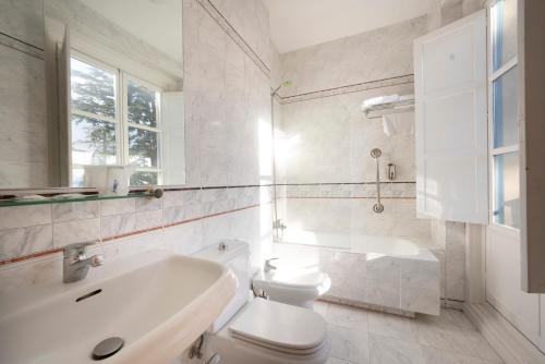 圣洛伦索-德埃斯科里亚尔米兰达与苏卓酒店的白色的浴室设有水槽和卫生间。