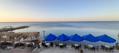 簇措罗斯圣乔吉奥酒店的海滩上的一组桌子和蓝色遮阳伞