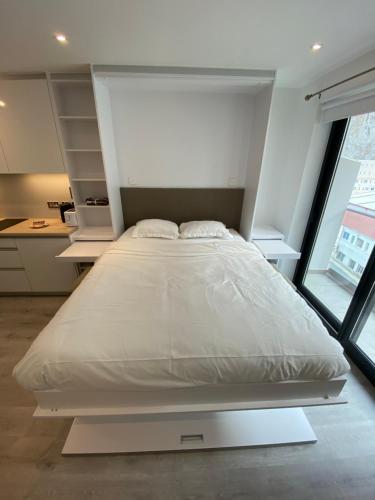 直布罗陀Modern Studio Apartment at The Hub的窗户客房内的一张大白色床