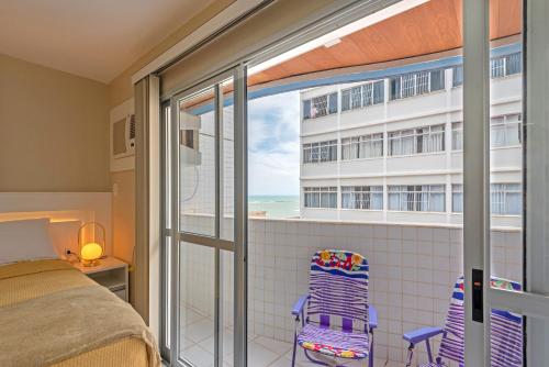 瓜拉派瑞Studio com vista para o mar no centro de Guarapari com Wifi的一间卧室设有一张床和一个海景阳台。