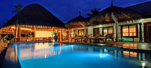 福拉杜岛Island Luxury Boutique Hotel - Fulhadhoo的夜间在房子前面的游泳池
