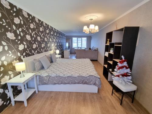 克拉斯拉瓦Kraslava 2 Bedroom Lux Apartments的一间卧室,配有一张床,里面有一棵圣诞树