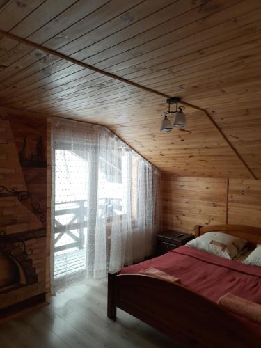 斯拉夫西克Guest House Stari Druzy的一间卧室设有一张床和一个大窗户