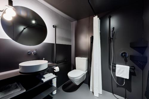 阿德尔博登Apart Hotel Adelboden am Dorfplatz的浴室配有卫生间、盥洗盆和淋浴。