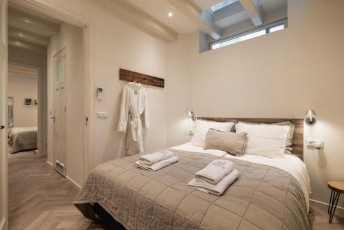 阿姆斯特丹Leidse Square 5 star Luxury Apartment的一间卧室配有一张大床和两条毛巾