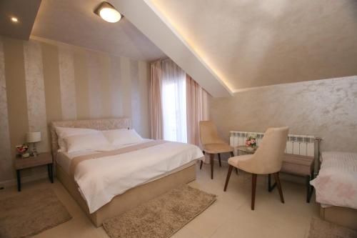 贝尔格莱德Bajadera Lux的卧室配有一张床和一张桌子及椅子