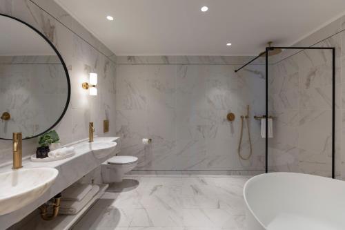 提比里亚Galei Kinneret Hotel的浴室设有2个水槽、卫生间和镜子。