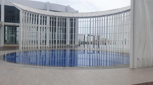 哥打巴鲁Prestige Troika Luxury Stay的建筑前的一座带游泳池的建筑