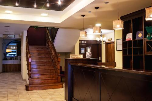 萨连特加列戈伊萨斯山谷酒店的一间酒吧,餐厅设有楼梯,灯光亮丽