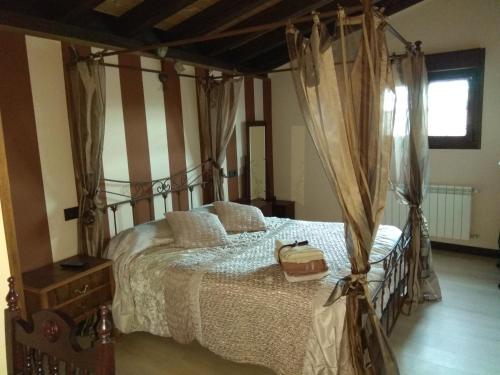 Modúbar de San Cibrián瑟尔卡德多纳希梅纳乡村民宿的一间卧室配有一张带袋子的天蓬床