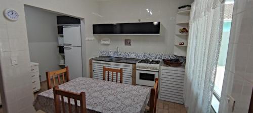 伊塔波阿Lindo Sobrado c/ Piscina e conforto próximo do mar的小厨房配有桌子和桌椅