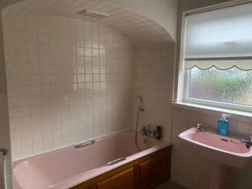 贝克斯利黑思Bexleyhealth Town Center 5 Bedroom Luxurious Home的一间带粉色浴缸和水槽的浴室