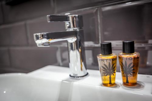热那亚博洛尼亚酒店 的浴室水槽上放有两瓶气味器