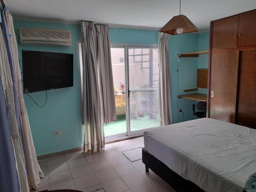 波萨达斯Casa cerca del microcentro y costanera的一间卧室配有一张床和一台平面电视
