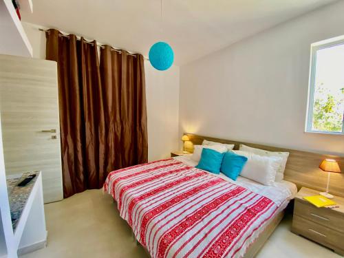 卡尔扎迈纳Marmaraki Village House & Apartments的一间卧室配有一张带蓝色枕头的大床