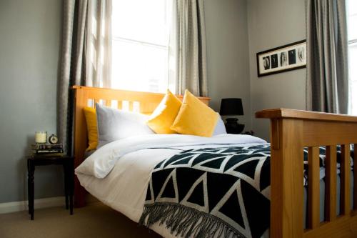 利物浦Characterful Abode with FREE parking.的一间卧室配有黄色和白色枕头的床