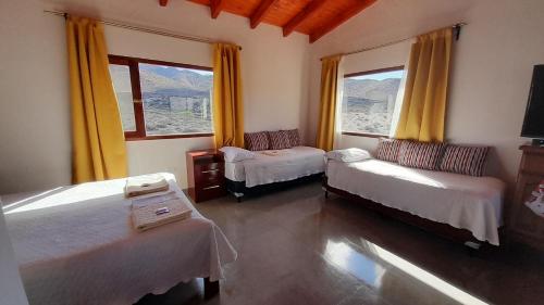 卡奇Cabaña Puertas del Cielo的客房设有两张床和窗户。