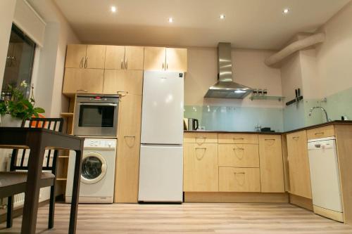 里加Brassy apartment的厨房配有白色冰箱和洗碗机。