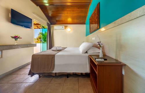塞古罗港Quinta do Sol Lite Praia Hotel的一间卧室设有一张床和木制天花板