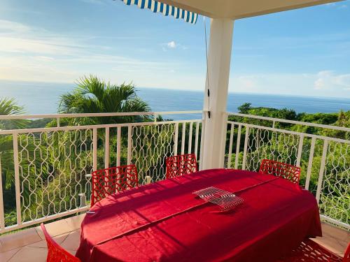 波尔兰特PARADIS AU SOLEIL, vue panoramique sur mer的阳台上的红色桌椅