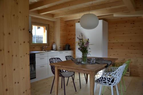 瓦尔斯Gääschi Leis的厨房设有木墙和木桌及椅子