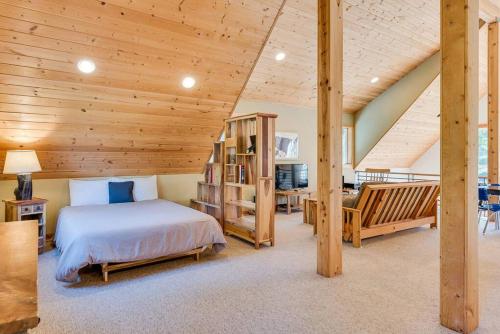 莱文沃思Hot Tub Cool Views: Roaring Creek Cabin的一间卧室设有一张床和木制天花板
