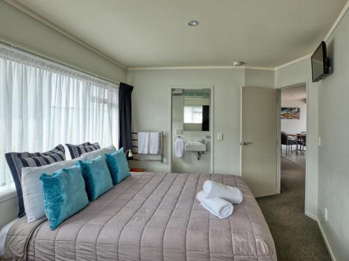 陶波Ika Nui Taupo的一间卧室配有一张带蓝白色枕头的大床