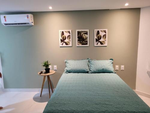 若昂佩索阿Espetacular Flat em Miramar 2的一间卧室配有一张带绿床罩的床