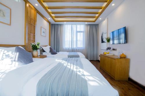 丽江丽江格麦尔精品度假酒店的一间大卧室,配有两张床和电视