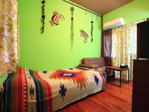 今归仁村精灵的罐子乡村民宿的一间卧室设有一张床和绿色的墙壁