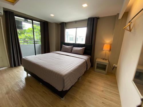 巴吞他尼Bansuay Bangkadi的一间卧室设有一张床和一个大窗户