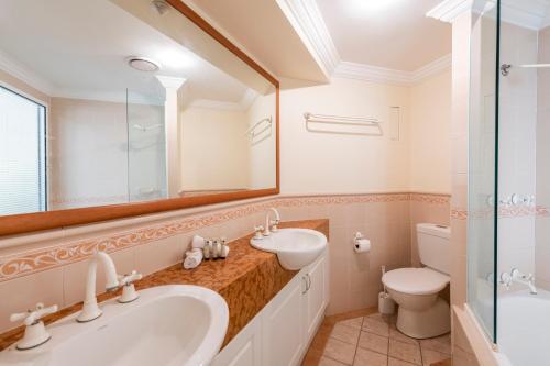 扬巴Breakers 1 3 LJHooker Yamba的一间带水槽、卫生间和镜子的浴室