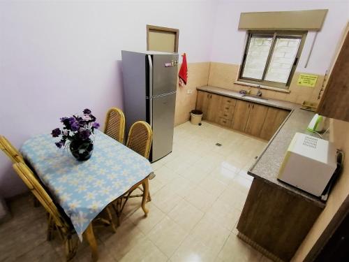 伯利恒和平之家酒店的一间带桌子和冰箱的小厨房