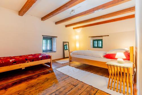 赖兴瑙Mühle in der Pferdewelt Reichenau的一间铺有木地板的客房内配有两张床的卧室
