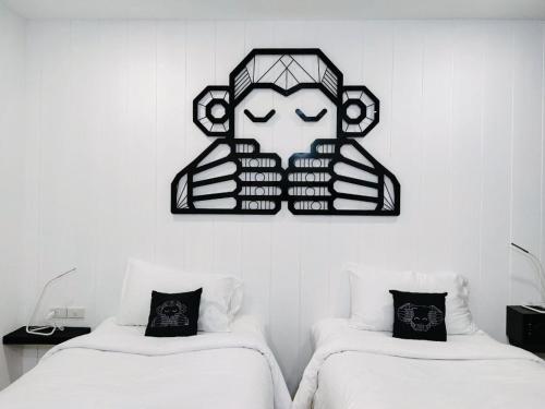 皮皮岛Blu Monkey Phi Phi Island的一间设有两张床的客房,墙上挂着一张照片