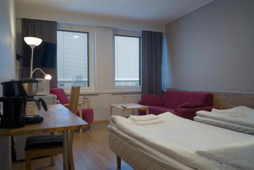 凯米Forenom Aparthotel Kemi的酒店客房带一张床、一张桌子和椅子