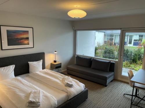 博托比Hotel Nørrevang的一间卧室配有一张床、一张沙发和一个窗口