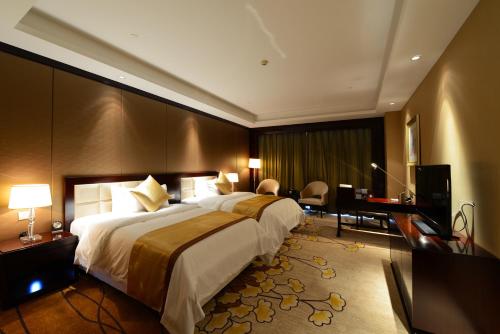 南京Jinling New Town Hotel Nanjing的酒店客房设有一张大床和一张书桌。