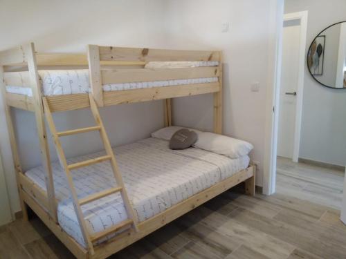 庞特维德拉Apartamento Ría de Vigo的一间卧室设有两张双层床和梯子