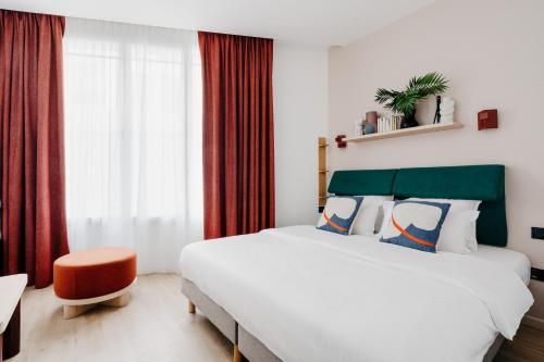巴黎Edgar Suites Auteuil - Le Marois的一间卧室设有一张大床和一个窗户。