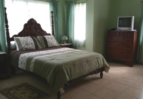 银沙Beautiful 2-Bed Apartment in sunny Jamaica的一间卧室配有一张带梳妆台和电视的床。