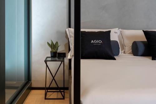 西维尔诺瓦·马尔凯Agio Comfy Place的一张带黑色枕头的床,旁边是边桌