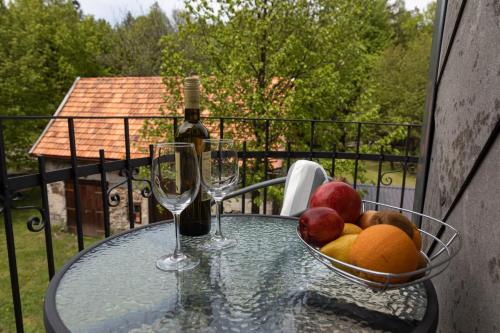 代尔尼采Apartman Tinče的玻璃桌,放一碗水果和两杯酒杯