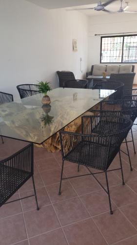 阿卡普尔科ACAPULCO DIAMANTE NUEVA E INCREIBLE VILLA CON ALBERCA PROPIA的客厅周围配有一张带椅子的大型木桌